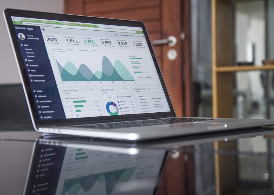 Dashboard with charts and data tables organized on a screen on a clean desk.